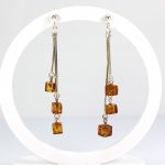 Kabantys gintariniai auskarai su trimis kubukais