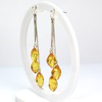 Kabantys gintariniai auskarai su trimis lašiukais